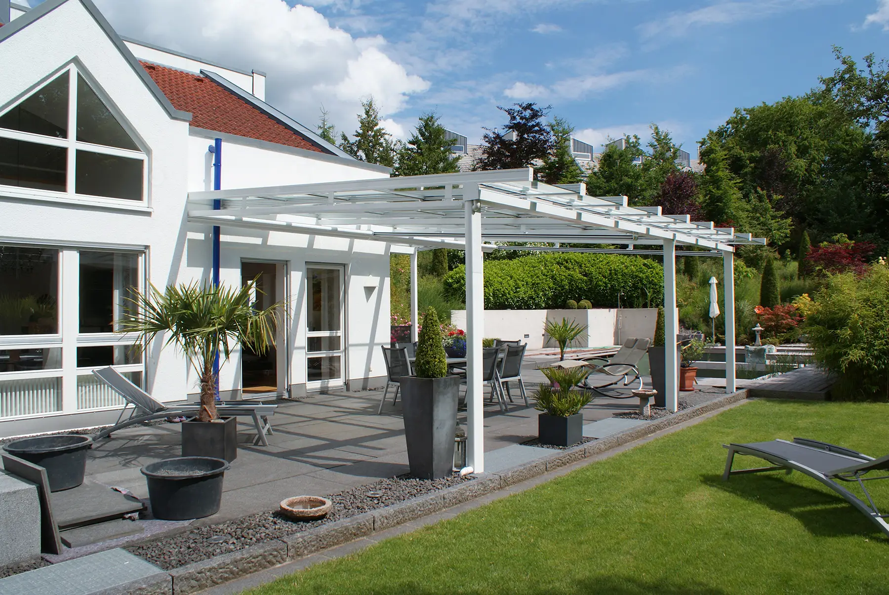 Anbau-Terrassenüberdachung aus weißem Aluminium mit einem variablen Vitello Flex Glasdach